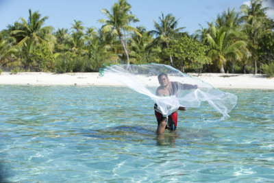 Polynesian fisherman in the lagoon of Tikehau, an island from the Tuamotu archipelago